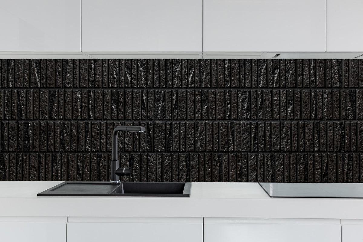 Küche - Panorama der modernen schwarzen Steinfliese hinter weißen Hochglanz-Küchenregalen und schwarzem Wasserhahn