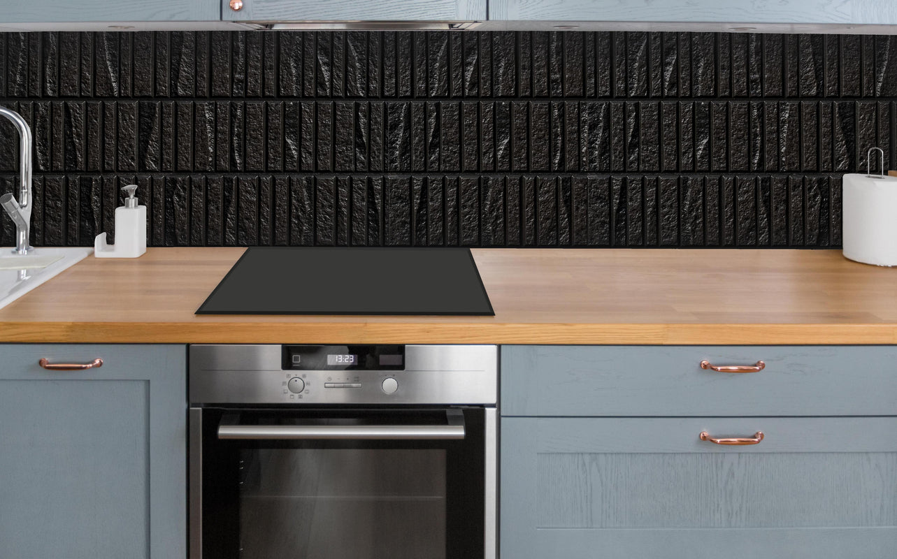 Küche - Panorama der modernen schwarzen Steinfliese über polierter Holzarbeitsplatte mit Cerankochfeld