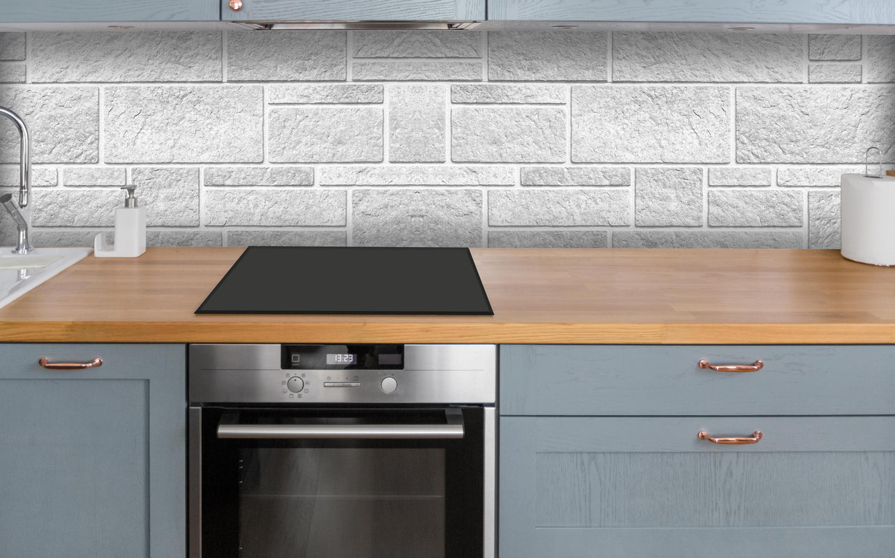 Küche - Panorama der rauen weißen Betonfliesen über polierter Holzarbeitsplatte mit Cerankochfeld