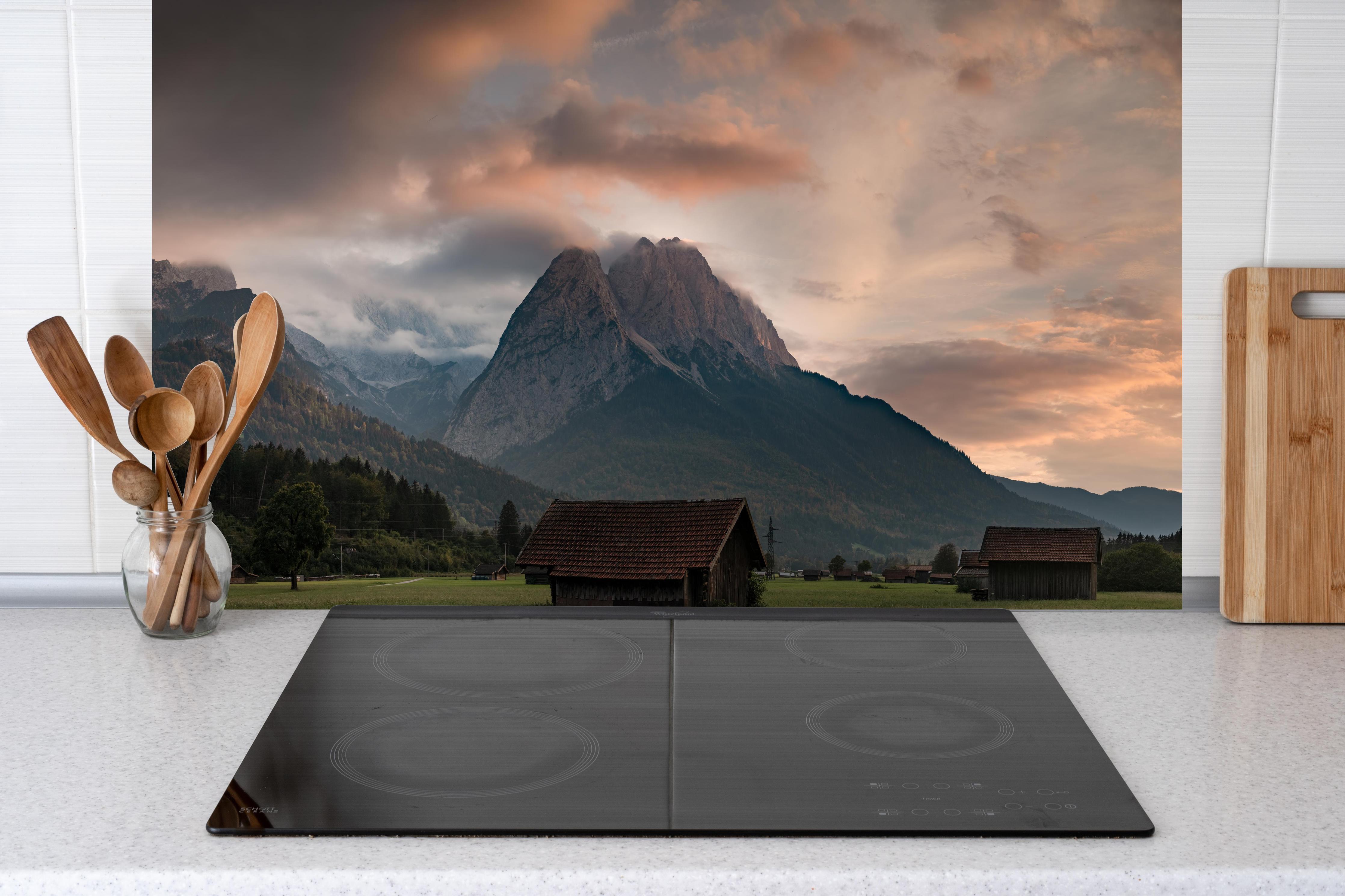 Küche - Panorama von der wolkenverhangenen Zugspitze hinter Cerankochfeld und Holz-Kochutensilien