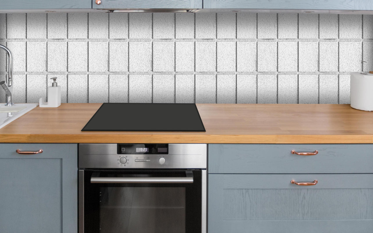 Küche - Panorama von weißem Betonblock Wand über polierter Holzarbeitsplatte mit Cerankochfeld