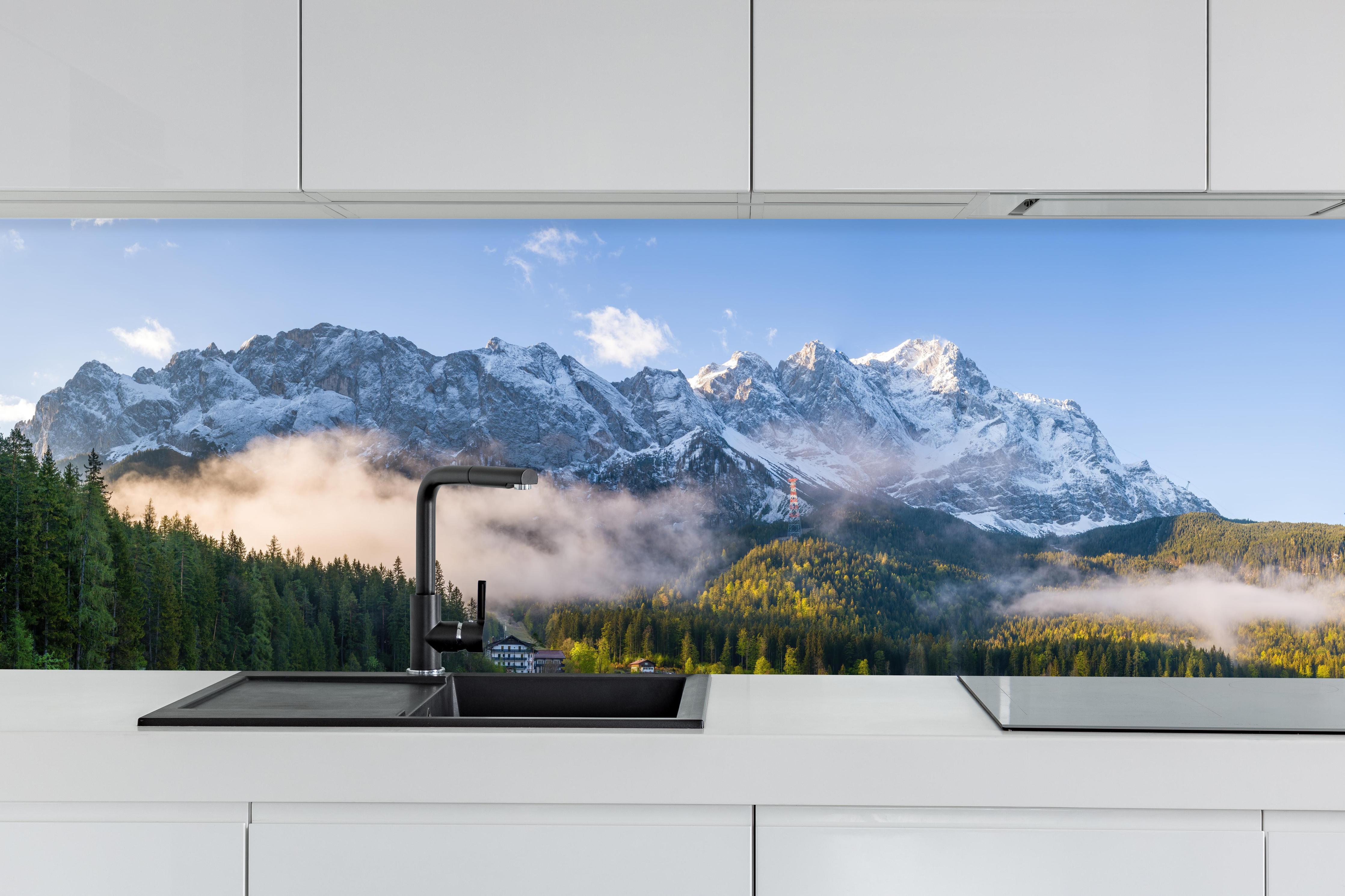 Küche - Panoramablick auf die Zugspitze hinter weißen Hochglanz-Küchenregalen und schwarzem Wasserhahn