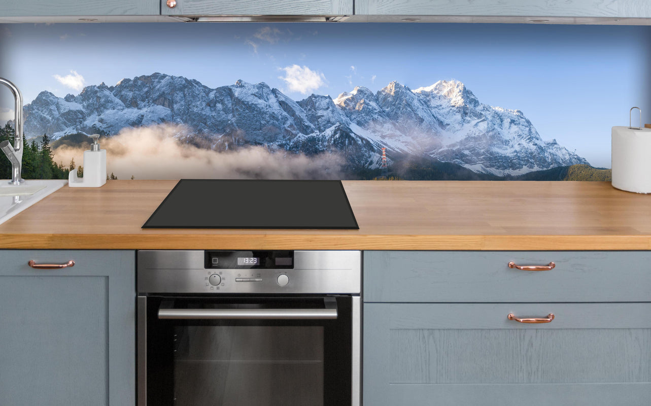 Küche - Panoramablick auf die Zugspitze über polierter Holzarbeitsplatte mit Cerankochfeld