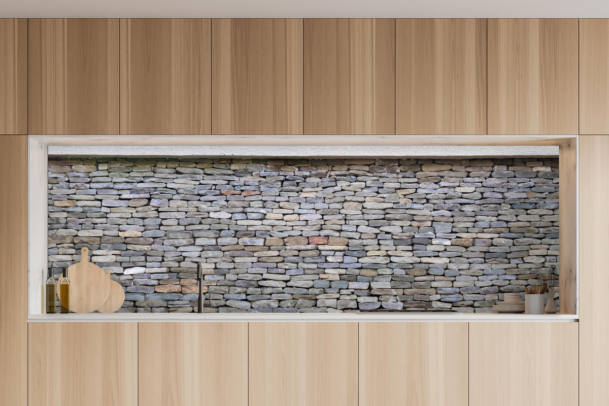 Küche - Pastellfarbene Steinmauer in charakteristischer Vollholz-Küche mit modernem Gasherd