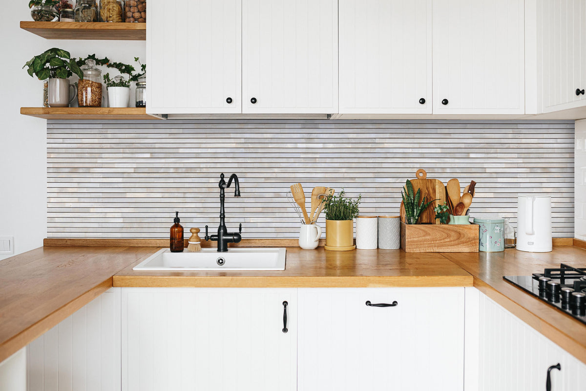Küche - Pastellfarbige Holzfassade in weißer Küche hinter Gewürzen und Kochlöffeln aus Holz