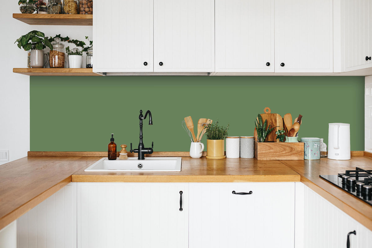 Küche - RAL 6011 (Reseda grün) in weißer Küche hinter Gewürzen und Kochlöffeln aus Holz