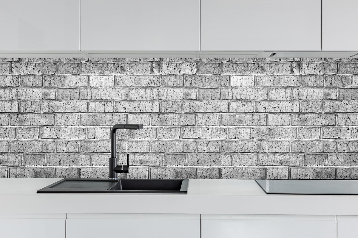Küche - Raues hellgraues Mauerwerk hinter weißen Hochglanz-Küchenregalen und schwarzem Wasserhahn