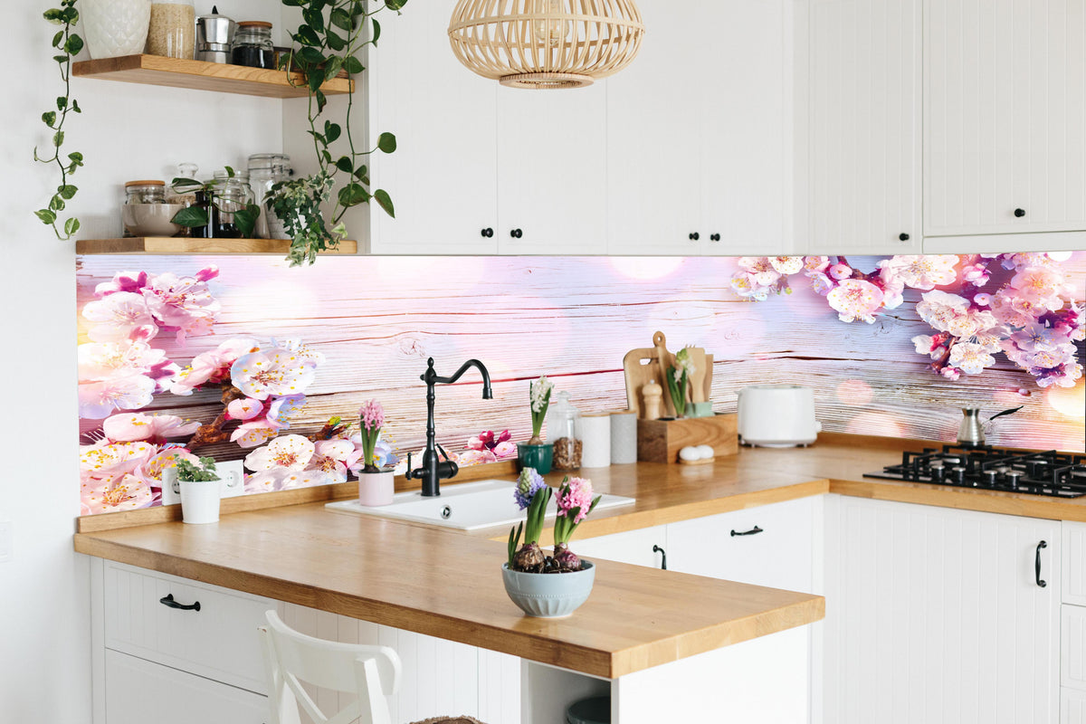 Küche - Rosa Blüten auf Holzplatte in lebendiger Küche mit bunten Blumen