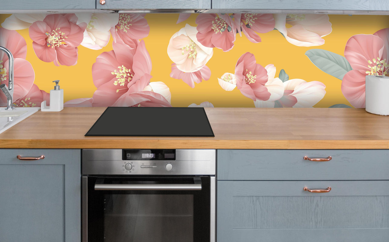 Küche - Rosa-weiße Blüten über polierter Holzarbeitsplatte mit Cerankochfeld