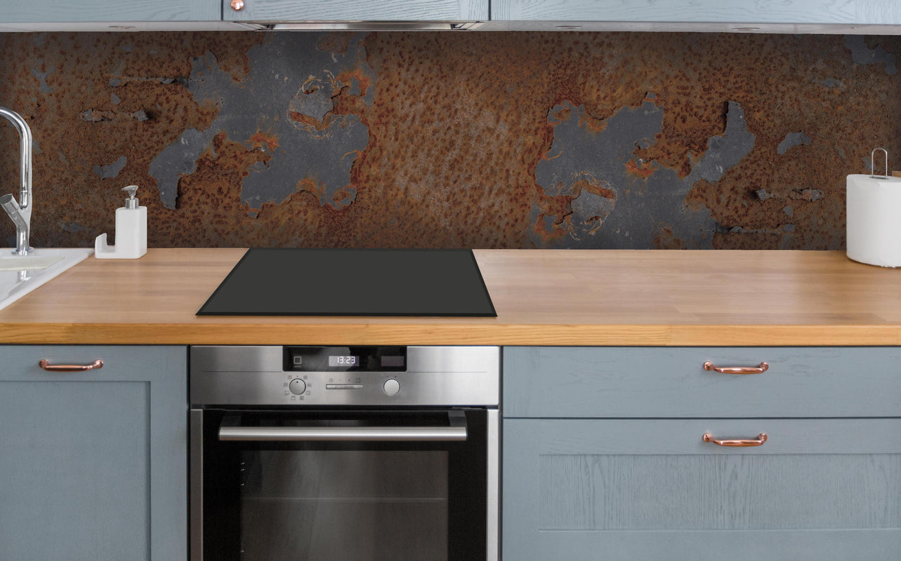 Küche - Rostiges Metall im Grunge-Stil über polierter Holzarbeitsplatte mit Cerankochfeld