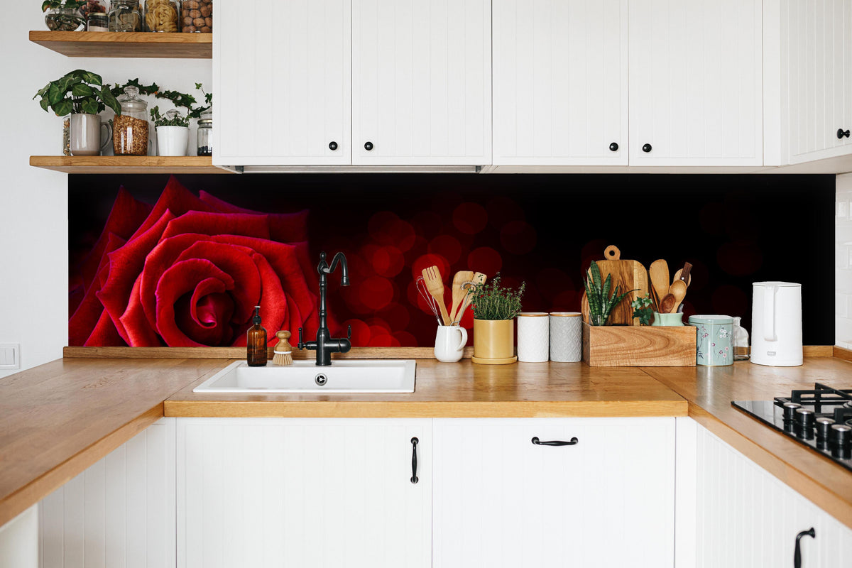 Küche - Rote Rose auf schwarzem Hintergrund in weißer Küche hinter Gewürzen und Kochlöffeln aus Holz