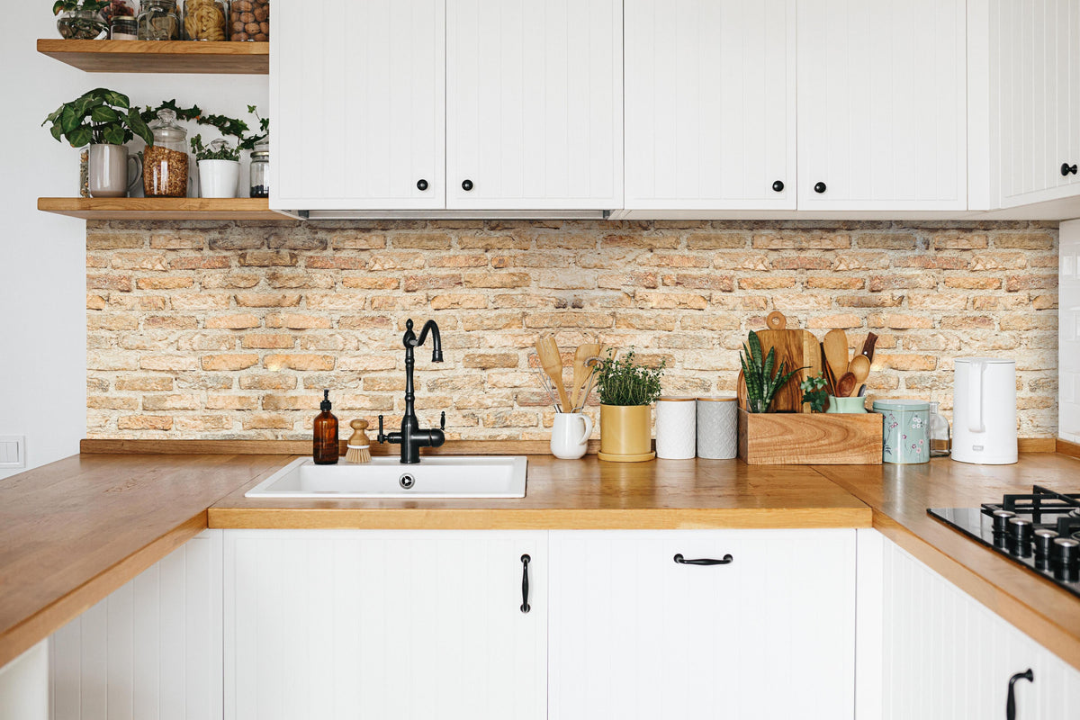 Küche - Rustikale Backsteinmauer in weißer Küche hinter Gewürzen und Kochlöffeln aus Holz