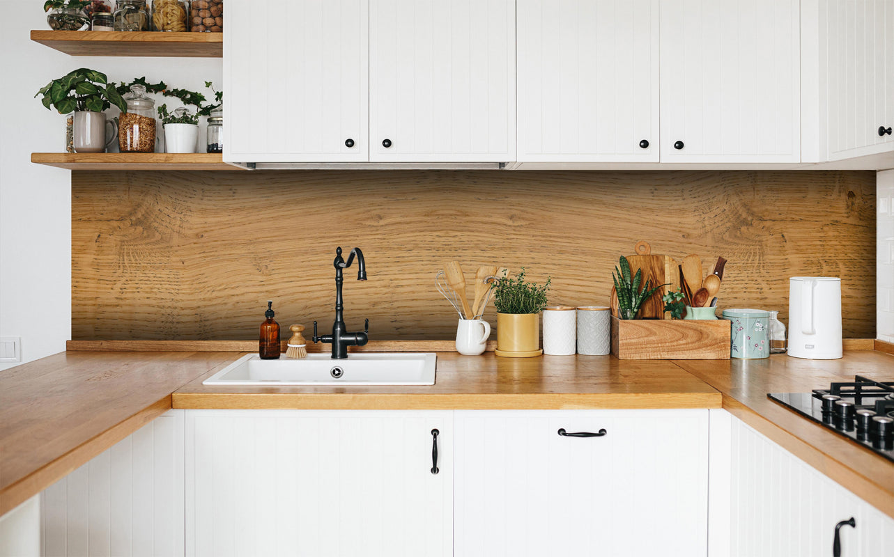 Küche - Schöne helle Holzplatte in weißer Küche hinter Gewürzen und Kochlöffeln aus Holz