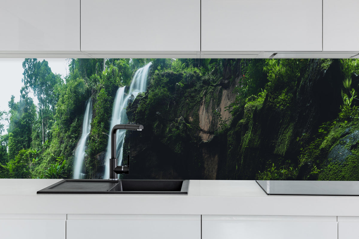 Küche - Schöner Wasserfall im Dschungel hinter weißen Hochglanz-Küchenregalen und schwarzem Wasserhahn