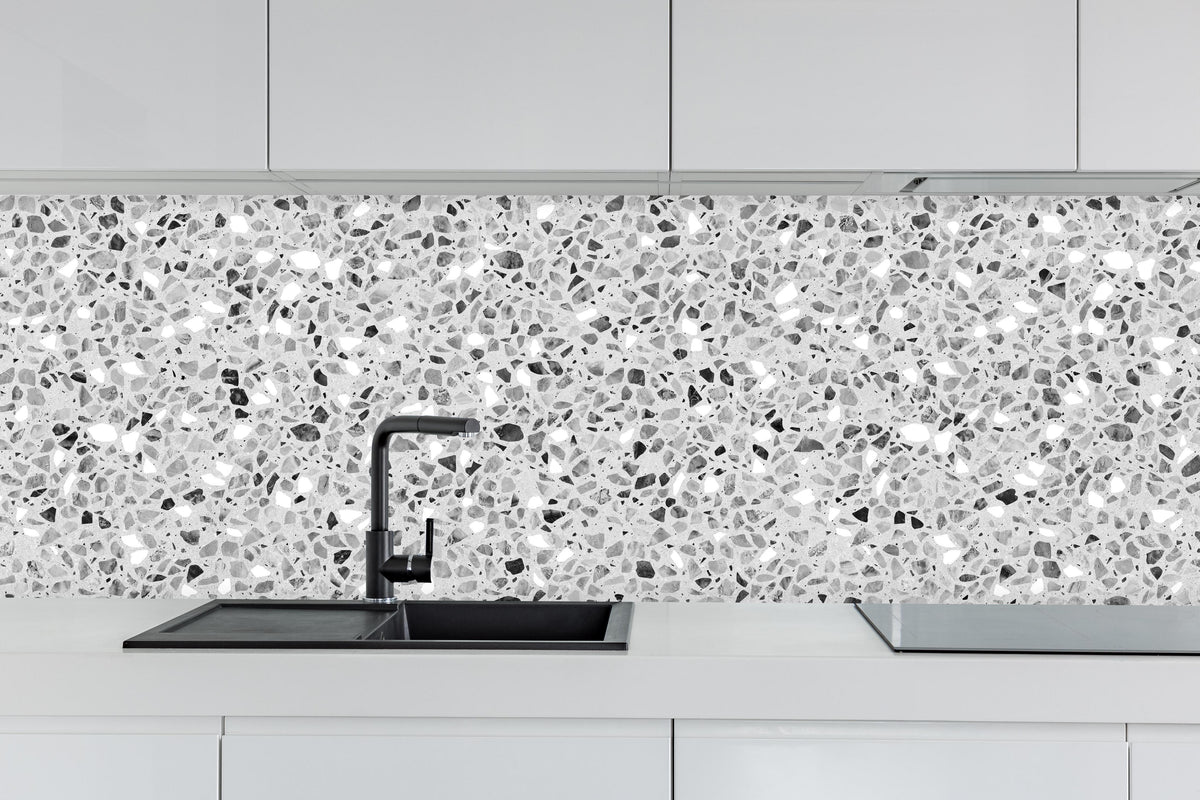 Küche - Schwarz-Weiße graue Terrazzo Stein Textur hinter weißen Hochglanz-Küchenregalen und schwarzem Wasserhahn