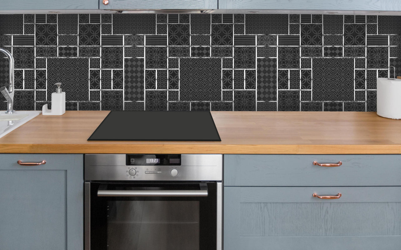 Küche - Schwarz geometrische Fliesen über polierter Holzarbeitsplatte mit Cerankochfeld