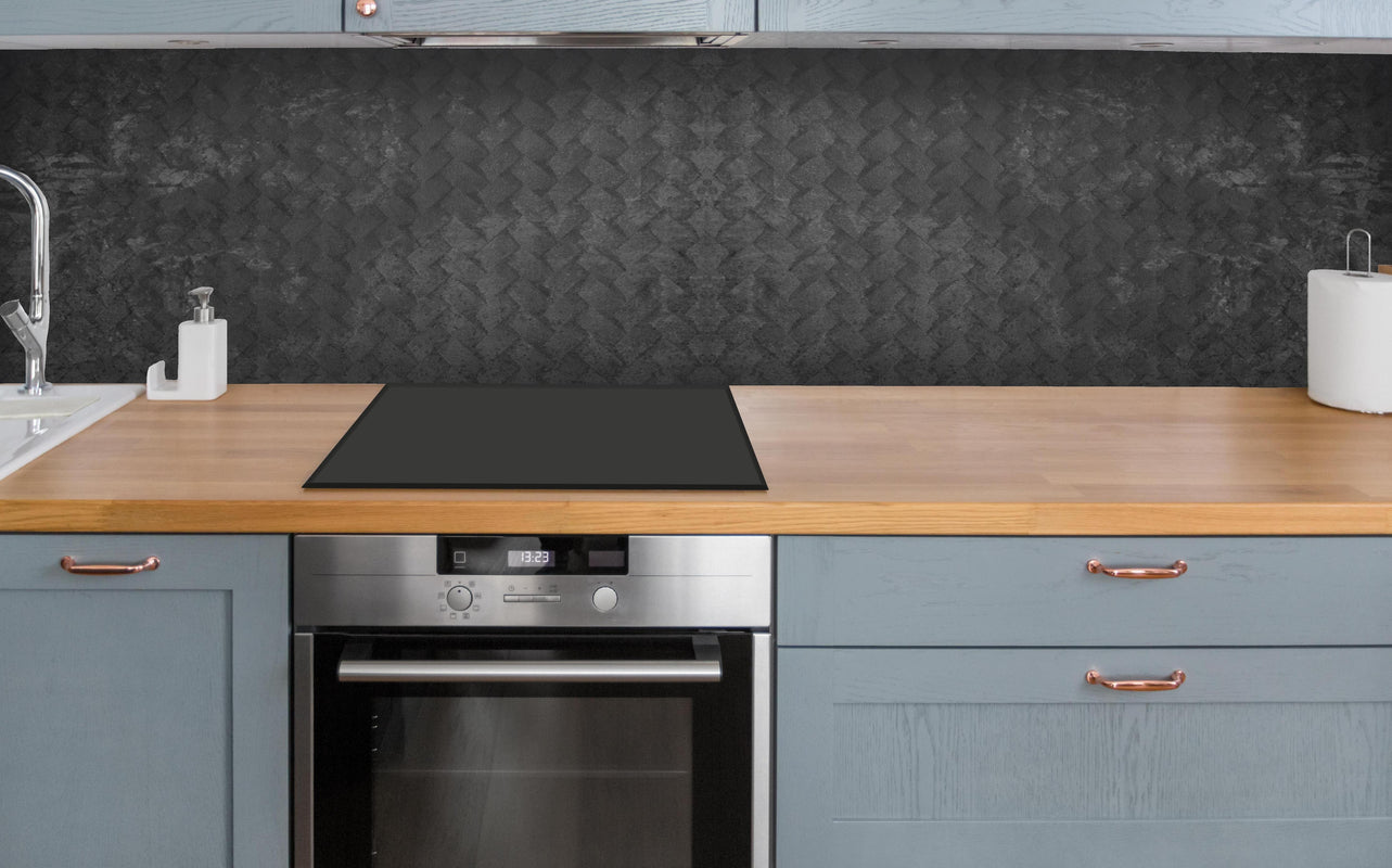 Küche - Schwarze geometrisches Betonwand über polierter Holzarbeitsplatte mit Cerankochfeld