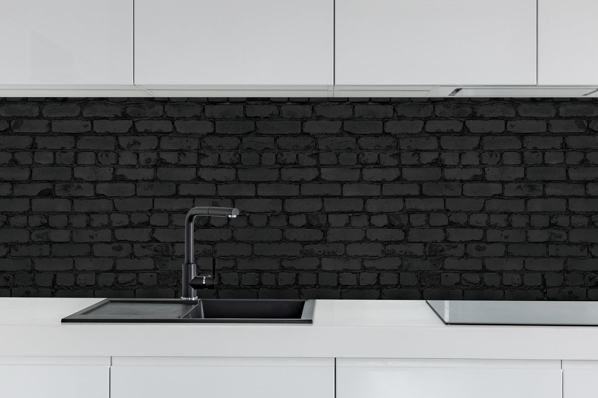 Küche - Schwarze raue Backsteinmauer hinter weißen Hochglanz-Küchenregalen und schwarzem Wasserhahn