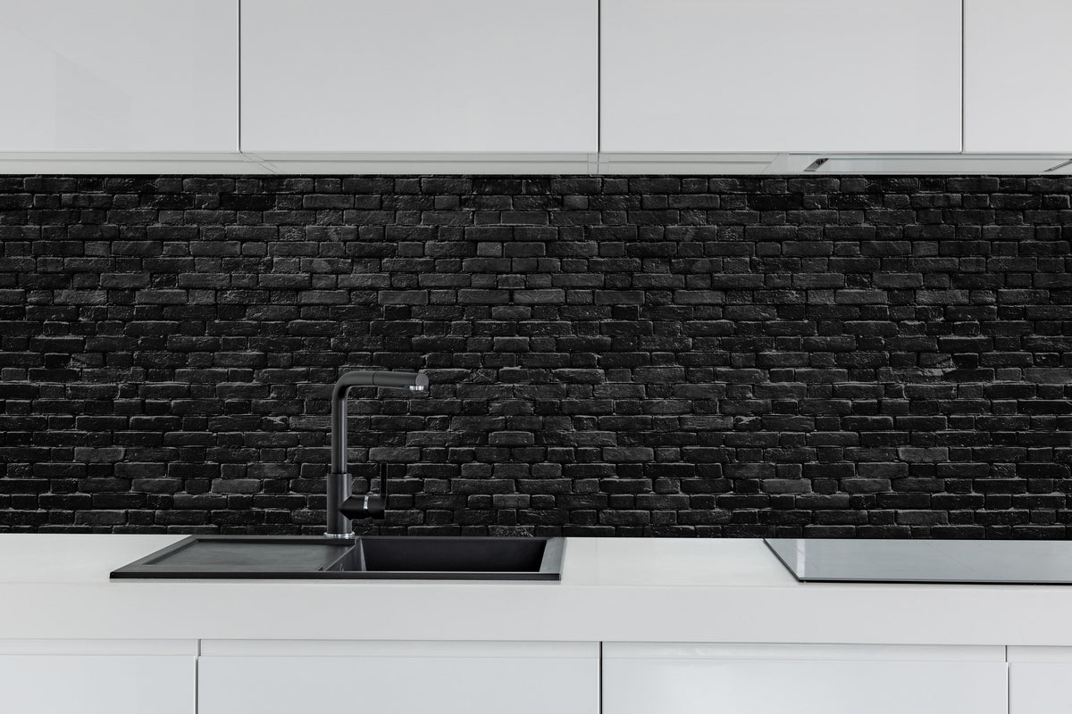 Küche - Schwarze raue Ziegelwand hinter weißen Hochglanz-Küchenregalen und schwarzem Wasserhahn