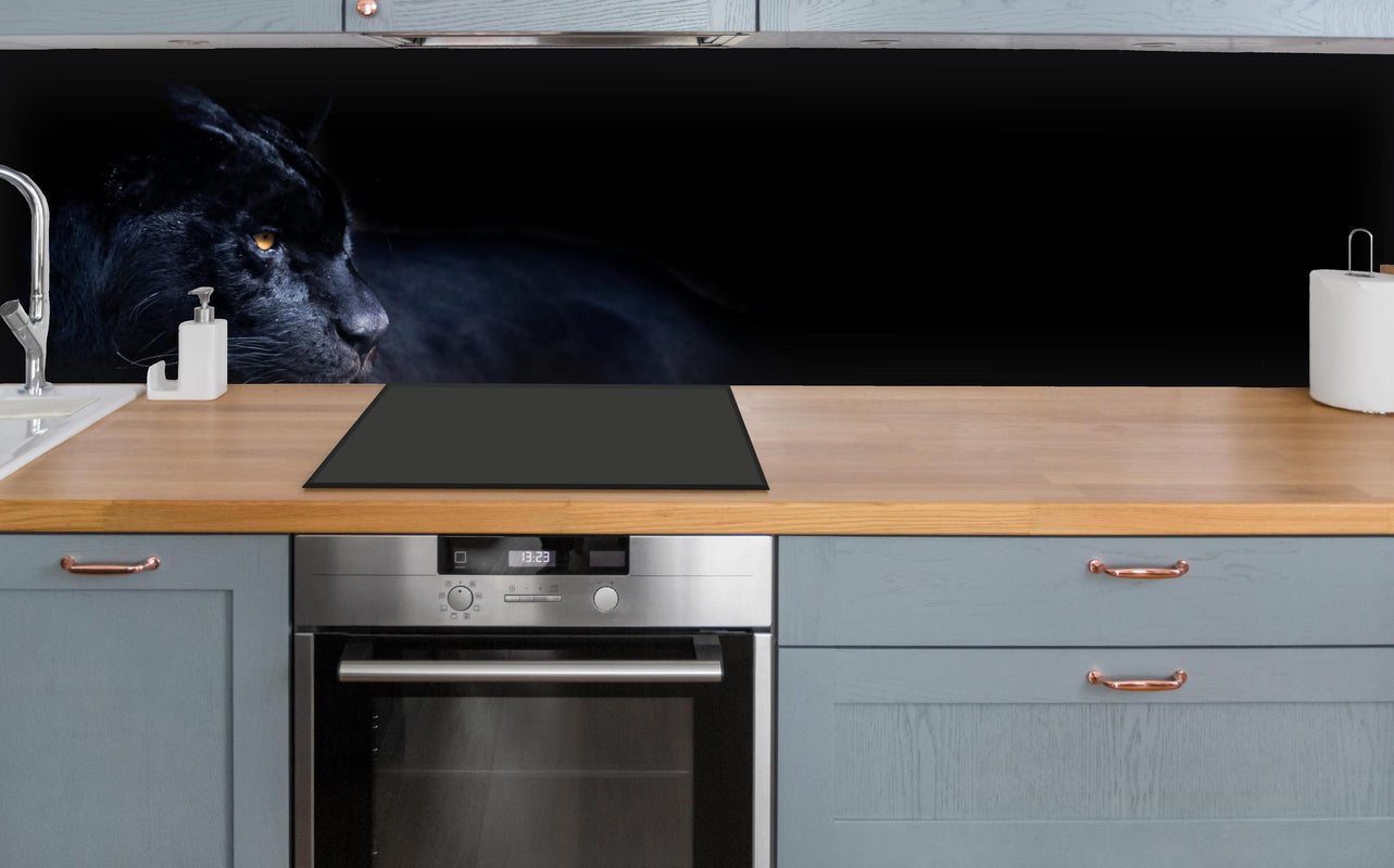Küche - Schwarzen Panther mit schwarzem Hintergrund über polierter Holzarbeitsplatte mit Cerankochfeld