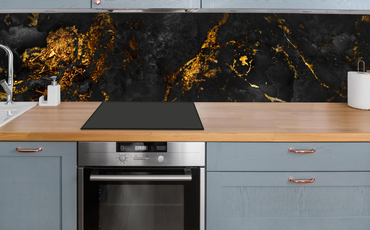 Küche - Schwarzer Marmor mit goldenen Adern über polierter Holzarbeitsplatte mit Cerankochfeld