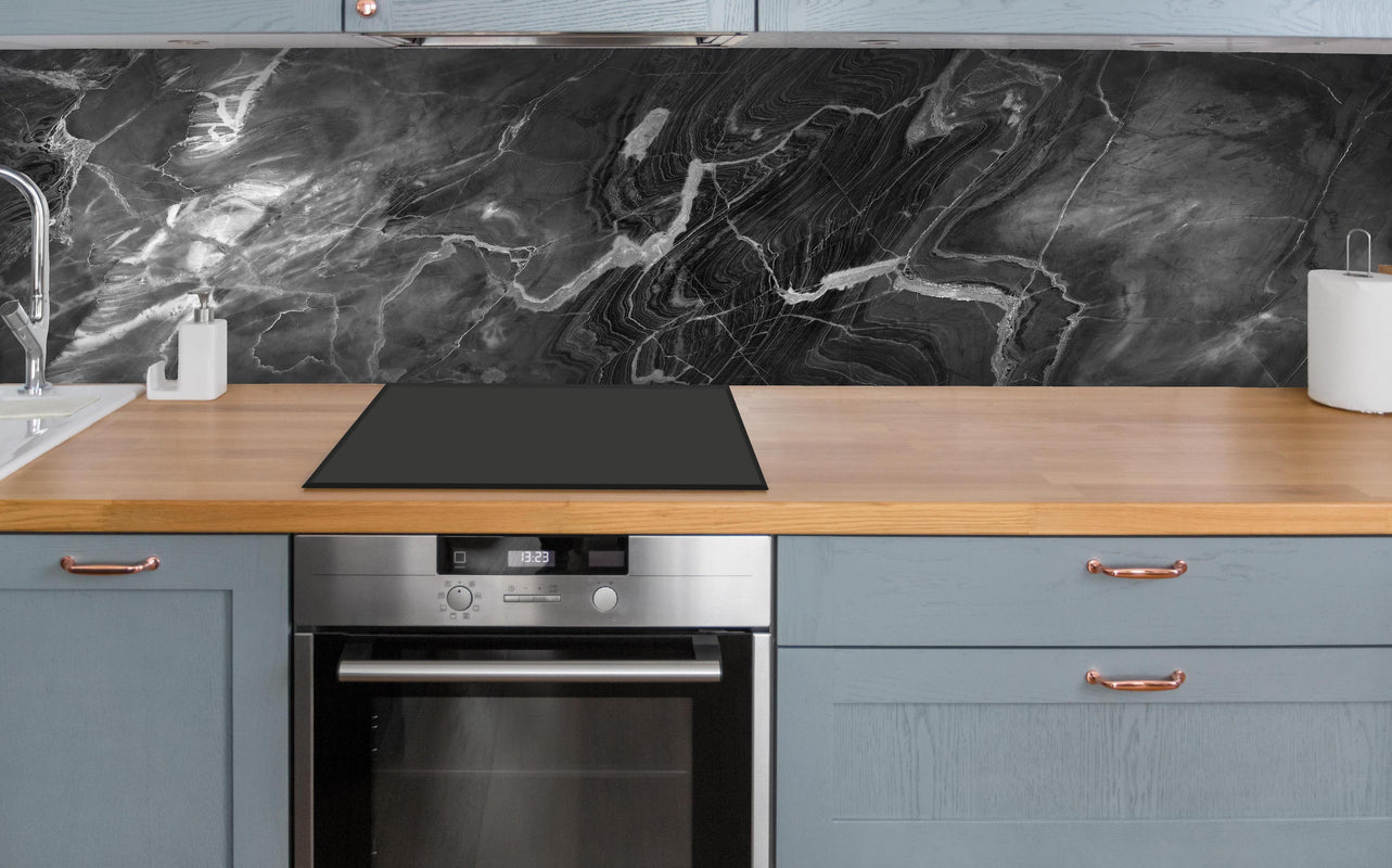 Küche - Schwarzer Marmor mit weißen Adern über polierter Holzarbeitsplatte mit Cerankochfeld
