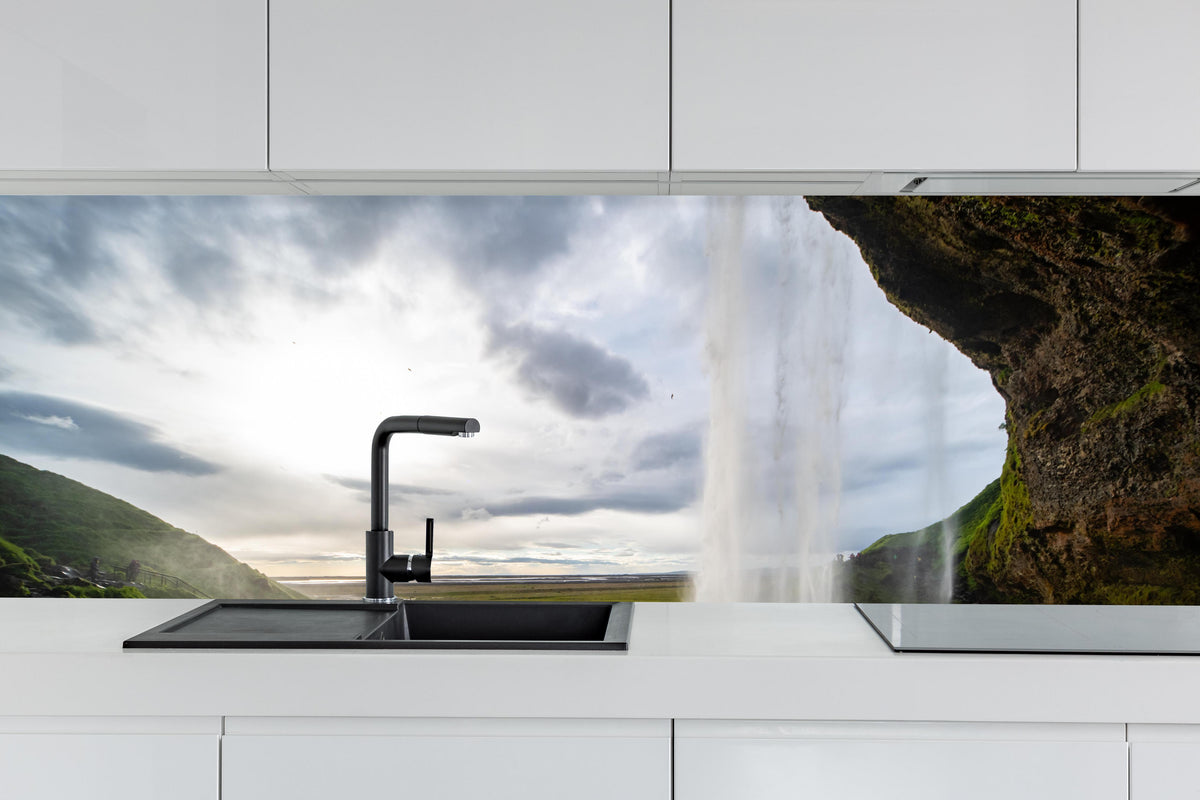 Küche - Seljalandsfoss Wasserfall hinter weißen Hochglanz-Küchenregalen und schwarzem Wasserhahn