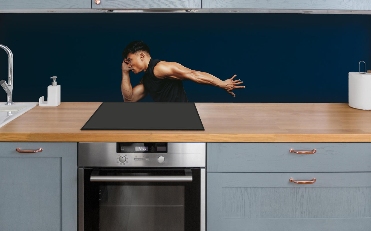 Küche - Sportler bei einem Sprung über polierter Holzarbeitsplatte mit Cerankochfeld