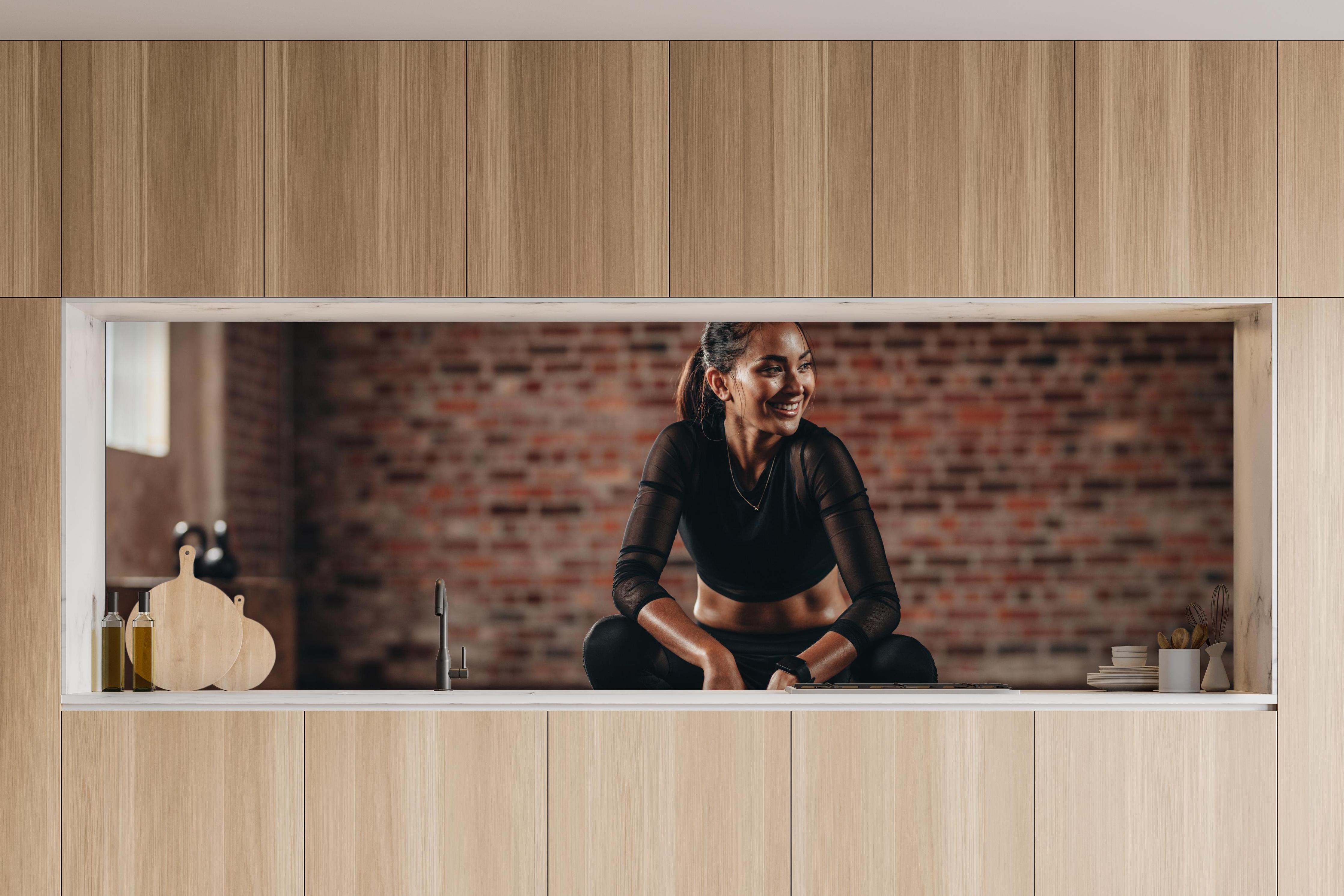 Küche - Sportlerin in der Hocke in charakteristischer Vollholz-Küche mit modernem Gasherd