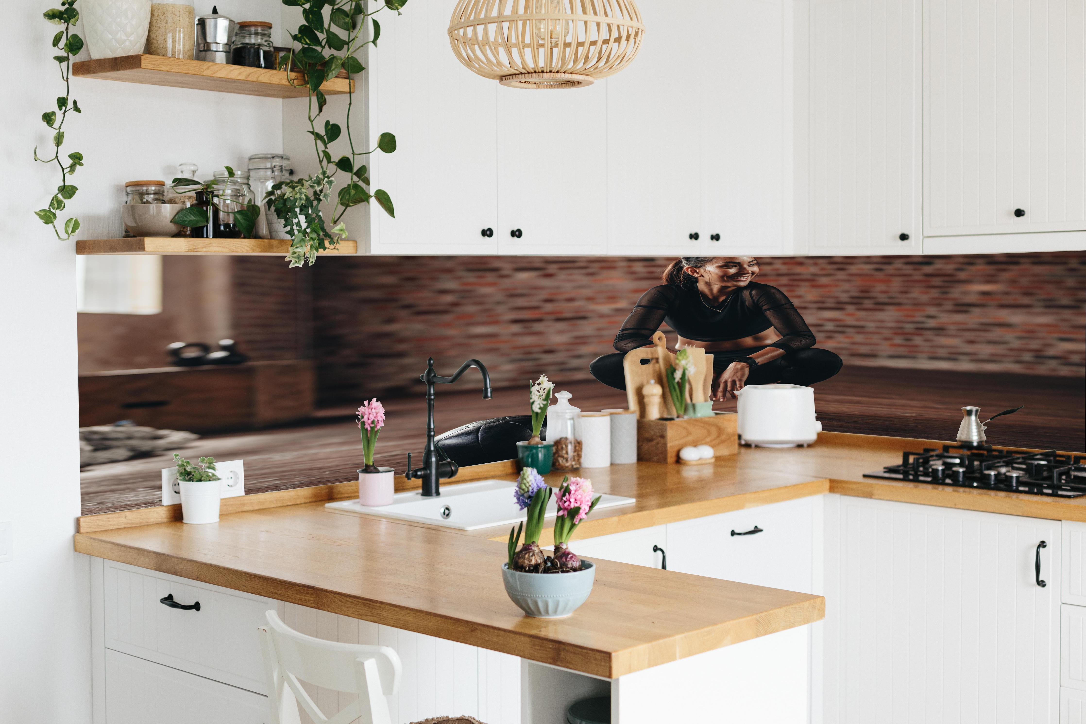 Küche - Sportlerin in der Hocke in lebendiger Küche mit bunten Blumen