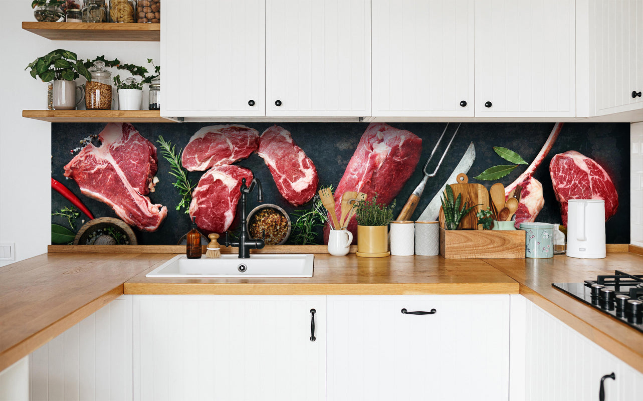 Küche - Steakvariationen auf Schieferplatte in weißer Küche hinter Gewürzen und Kochlöffeln aus Holz