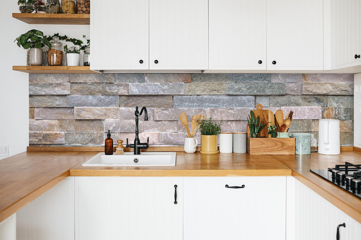 Küche - Steinwand aus groben in weißer Küche hinter Gewürzen und Kochlöffeln aus Holz