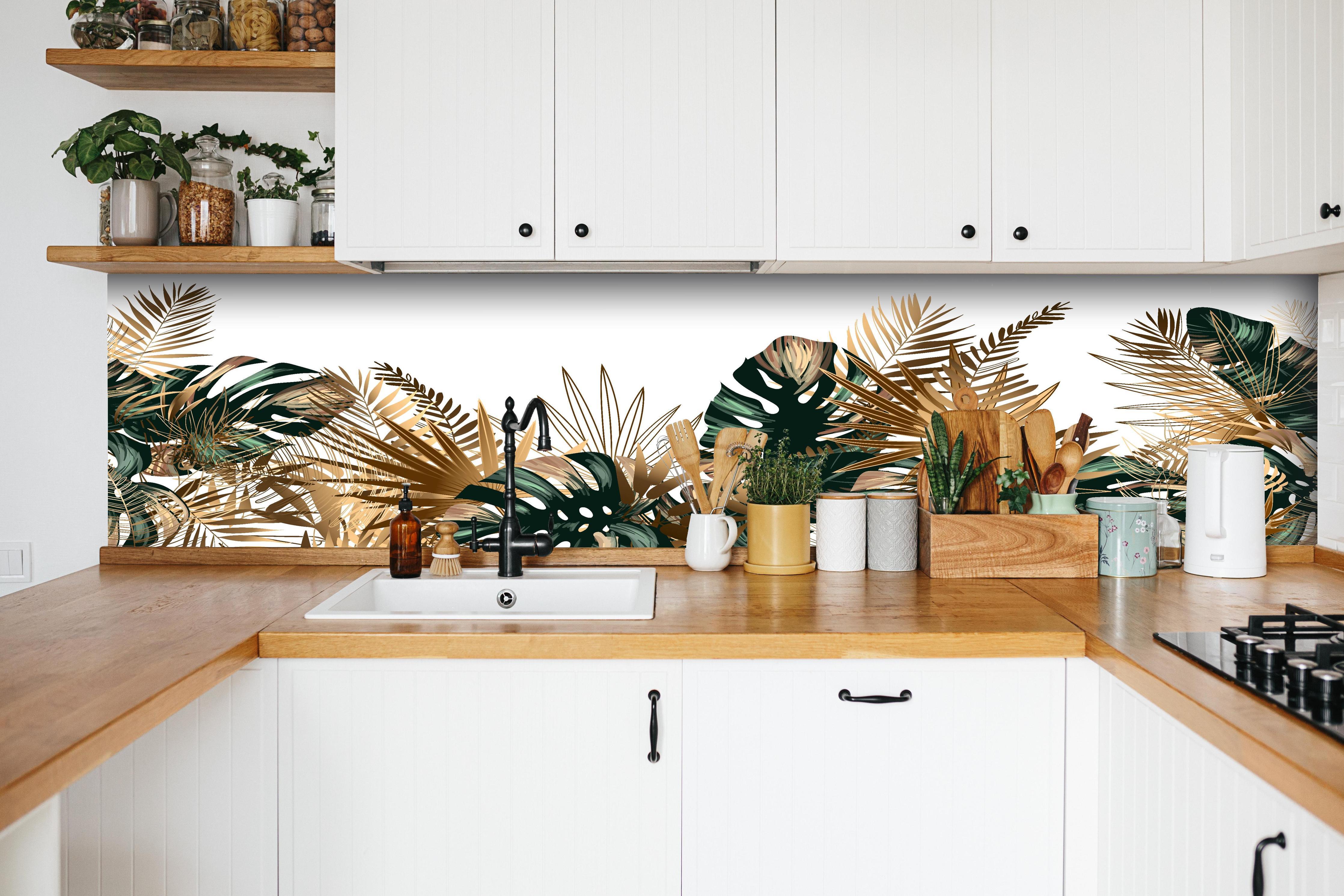 Küche - Tropische Gold-Palmen Dekor in weißer Küche hinter Gewürzen und Kochlöffeln aus Holz