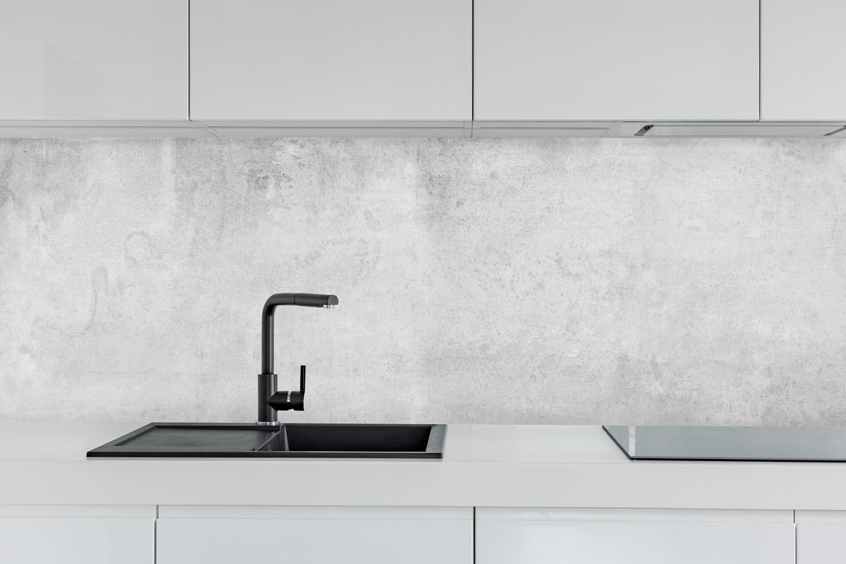 Küche - Verwitterte graue Zementwand hinter weißen Hochglanz-Küchenregalen und schwarzem Wasserhahn