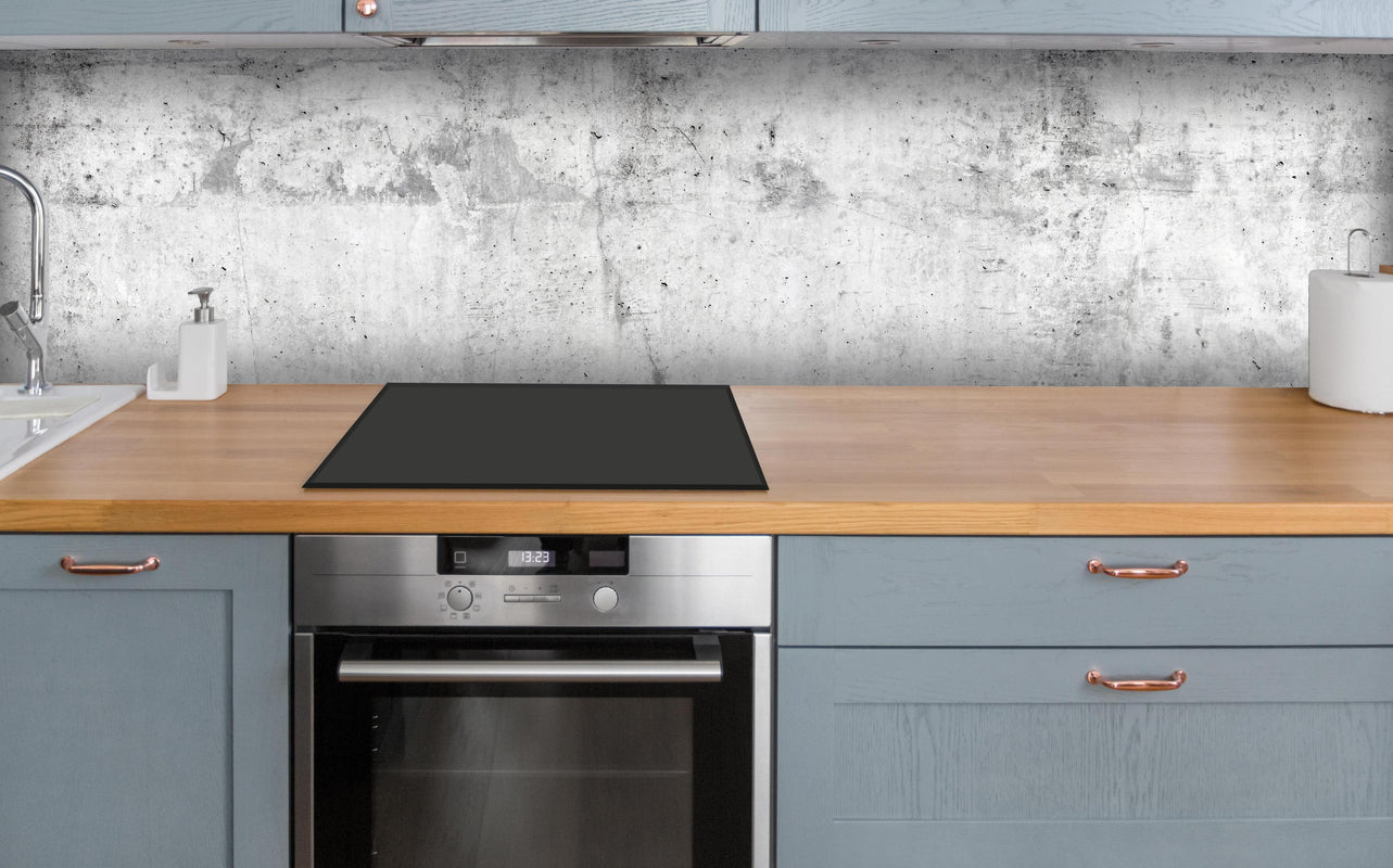 Küche - Verwitterte weiße Betonwandtextur über polierter Holzarbeitsplatte mit Cerankochfeld