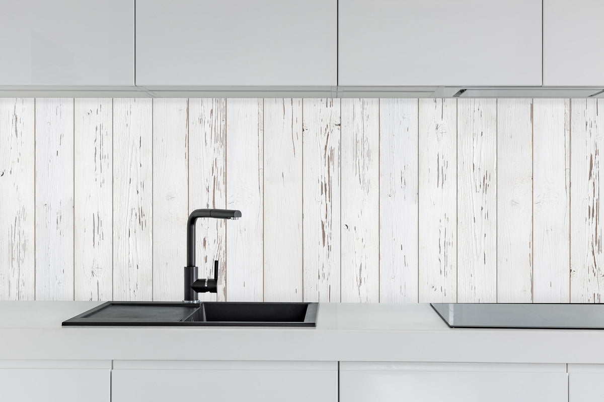 Küche - Verwitterte weiße Holzdielen hinter weißen Hochglanz-Küchenregalen und schwarzem Wasserhahn