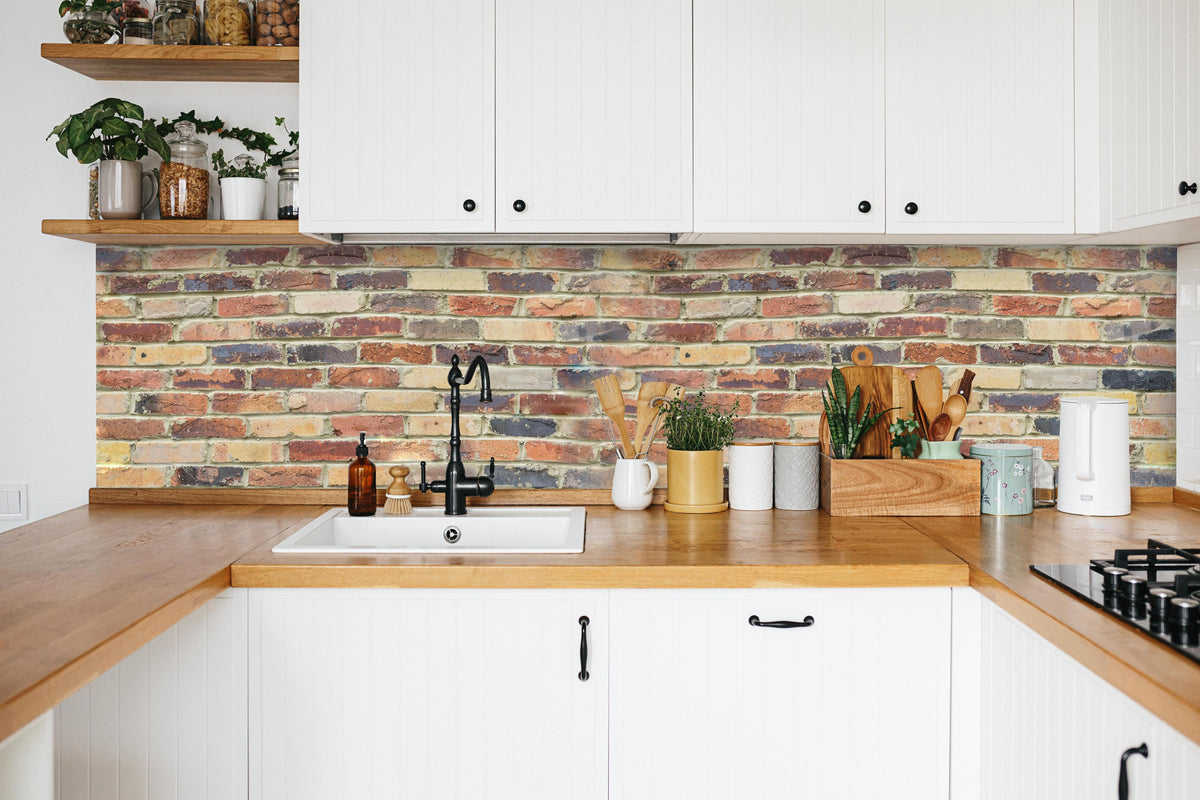 Küche - Wand aus farbigen Ziegeln in weißer Küche hinter Gewürzen und Kochlöffeln aus Holz