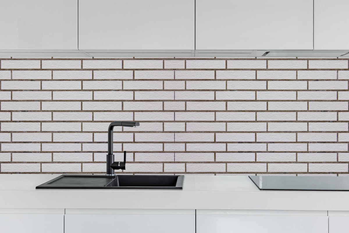Küche - Weiß-Brauner Backsteinmauer hinter weißen Hochglanz-Küchenregalen und schwarzem Wasserhahn