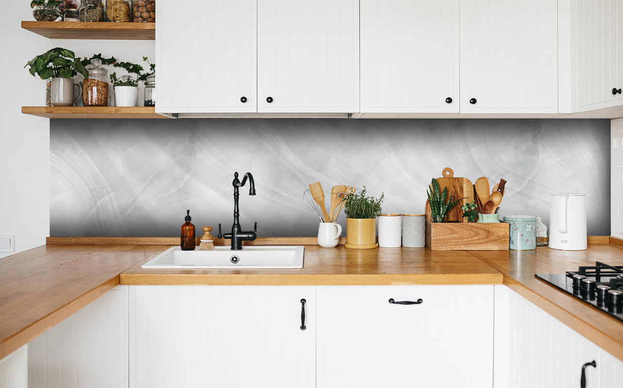 Küche - Weiß-Grauer Marmor in weißer Küche hinter Gewürzen und Kochlöffeln aus Holz