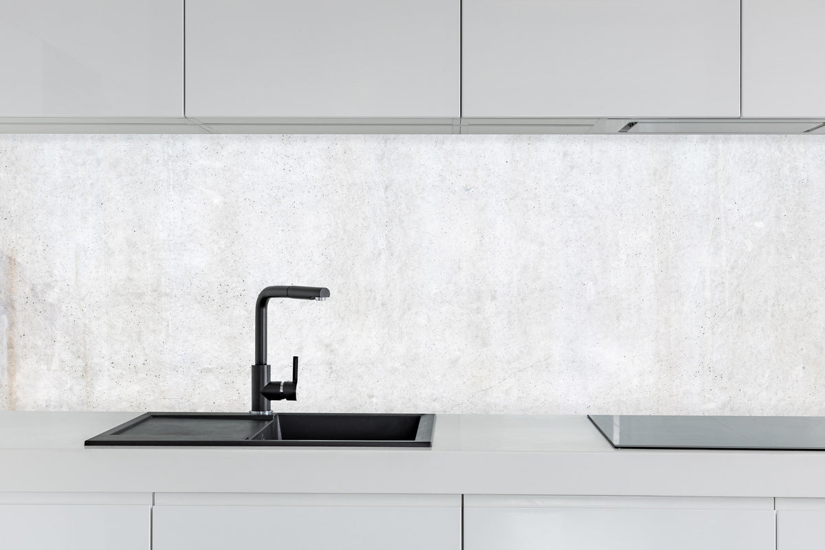 Küche - Weiß-bläuliche Betonwand hinter weißen Hochglanz-Küchenregalen und schwarzem Wasserhahn