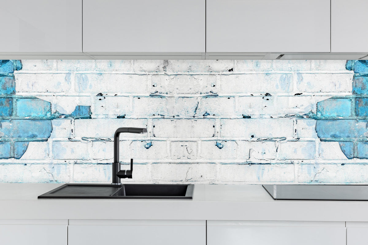 Küche - Weiß blau beschädigte Backsteinmauer hinter weißen Hochglanz-Küchenregalen und schwarzem Wasserhahn