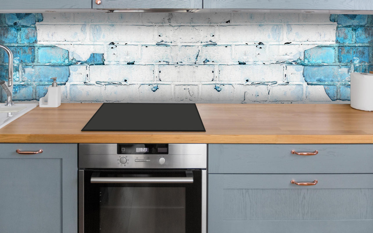 Küche - Weiß blau beschädigte Backsteinmauer über polierter Holzarbeitsplatte mit Cerankochfeld
