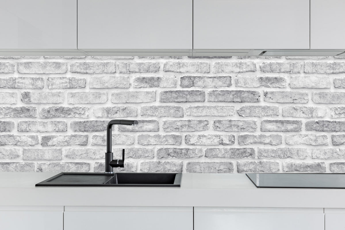 Küche - Weiß gewaschene Ziegelwand hinter weißen Hochglanz-Küchenregalen und schwarzem Wasserhahn