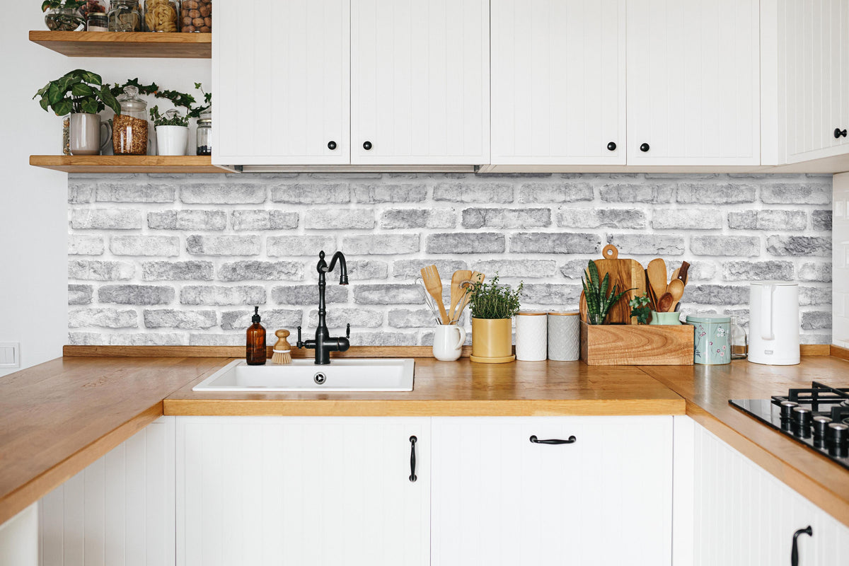 Küche - Weiß gewaschene Ziegelwand in weißer Küche hinter Gewürzen und Kochlöffeln aus Holz