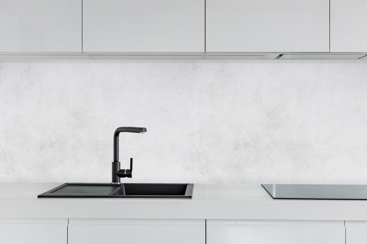 Küche - Weiß-gräuliche Betonwand hinter weißen Hochglanz-Küchenregalen und schwarzem Wasserhahn