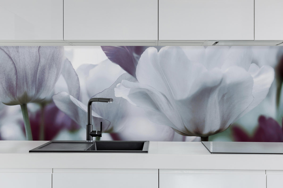 Küche - Weiße Tulpen hinter weißen Hochglanz-Küchenregalen und schwarzem Wasserhahn