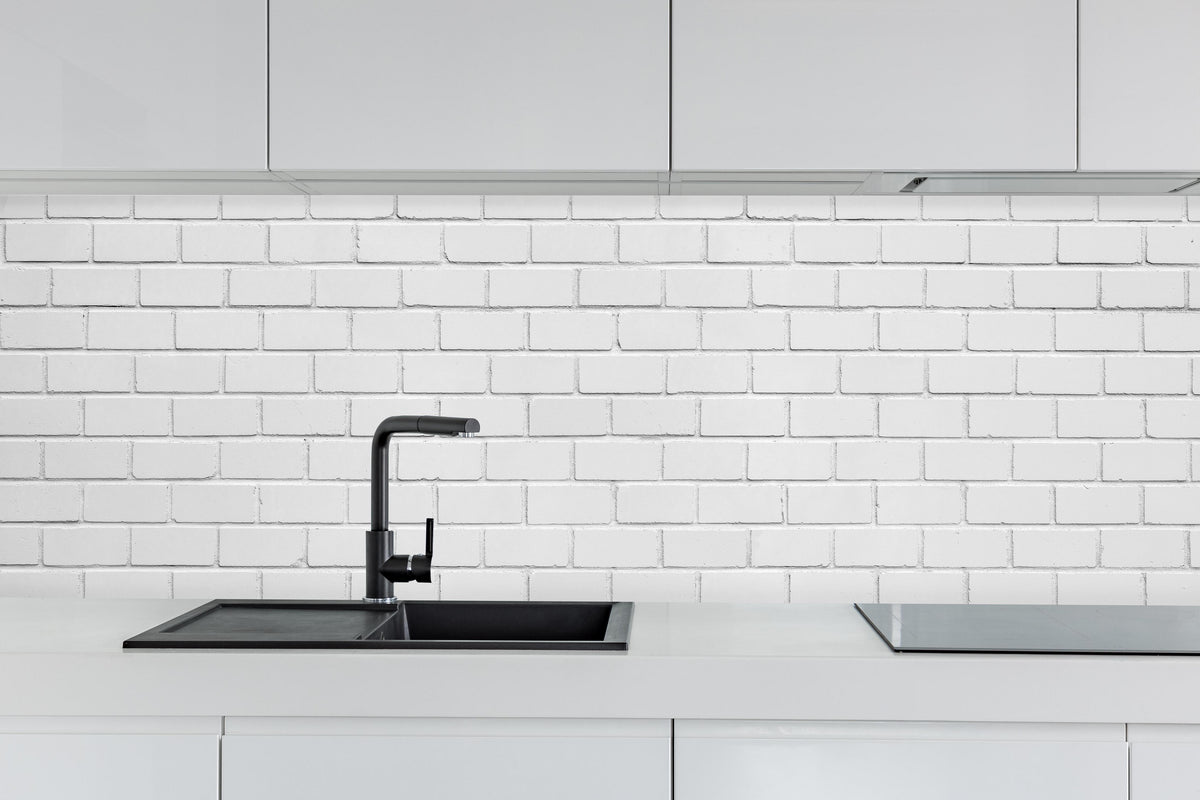 Küche - Weiße Ziegelwand - Zement hinter weißen Hochglanz-Küchenregalen und schwarzem Wasserhahn