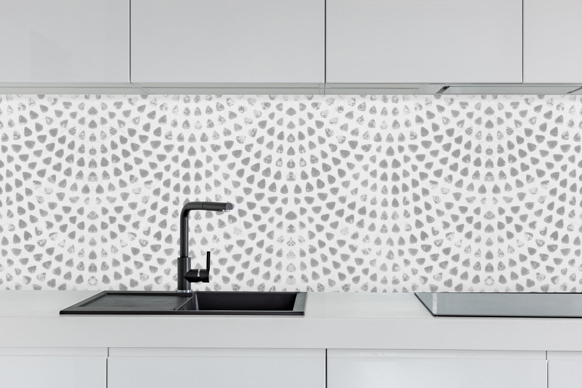 Küche - Weiße geometrisches Stempelmuster hinter weißen Hochglanz-Küchenregalen und schwarzem Wasserhahn