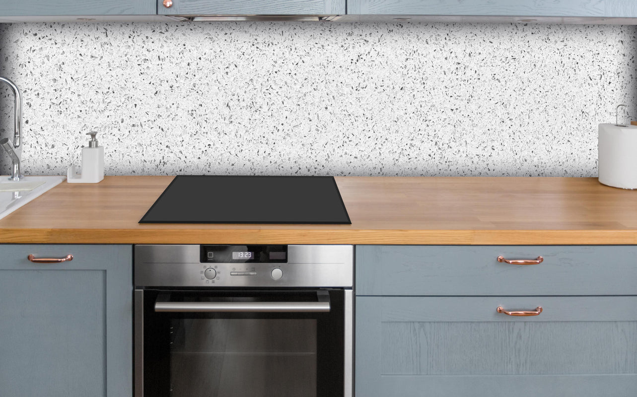 Küche - Weiße gepunktete Quarzoberfläche über polierter Holzarbeitsplatte mit Cerankochfeld