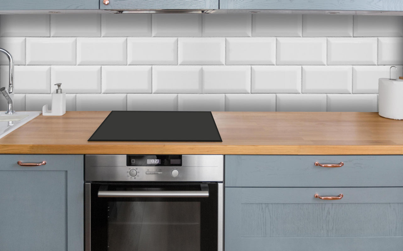Küche - Weiße helle glänzende Ziegelfliesen über polierter Holzarbeitsplatte mit Cerankochfeld